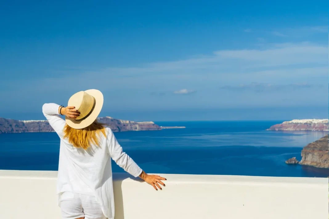 Femme regardant la mer depuis une terrasse en Europe.