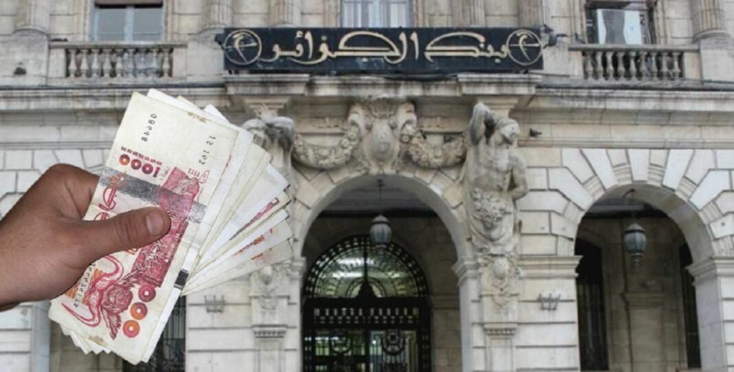 Main tenant des billets de banque devant la Banque d'Algérie.