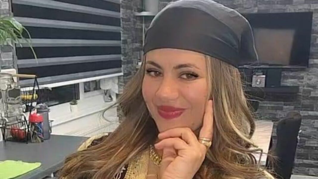 Nawel UK souriante portant un bonnet noir dans un décor moderne.