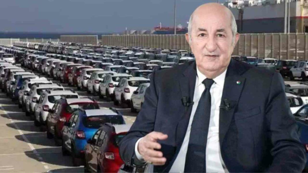 Homme en costume devant un grand parking de voitures neuves.