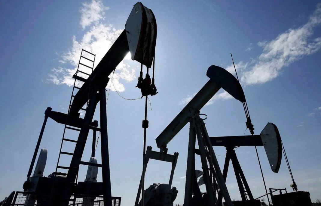 Puits de pétrole en activité sous un ciel ensoleillé.