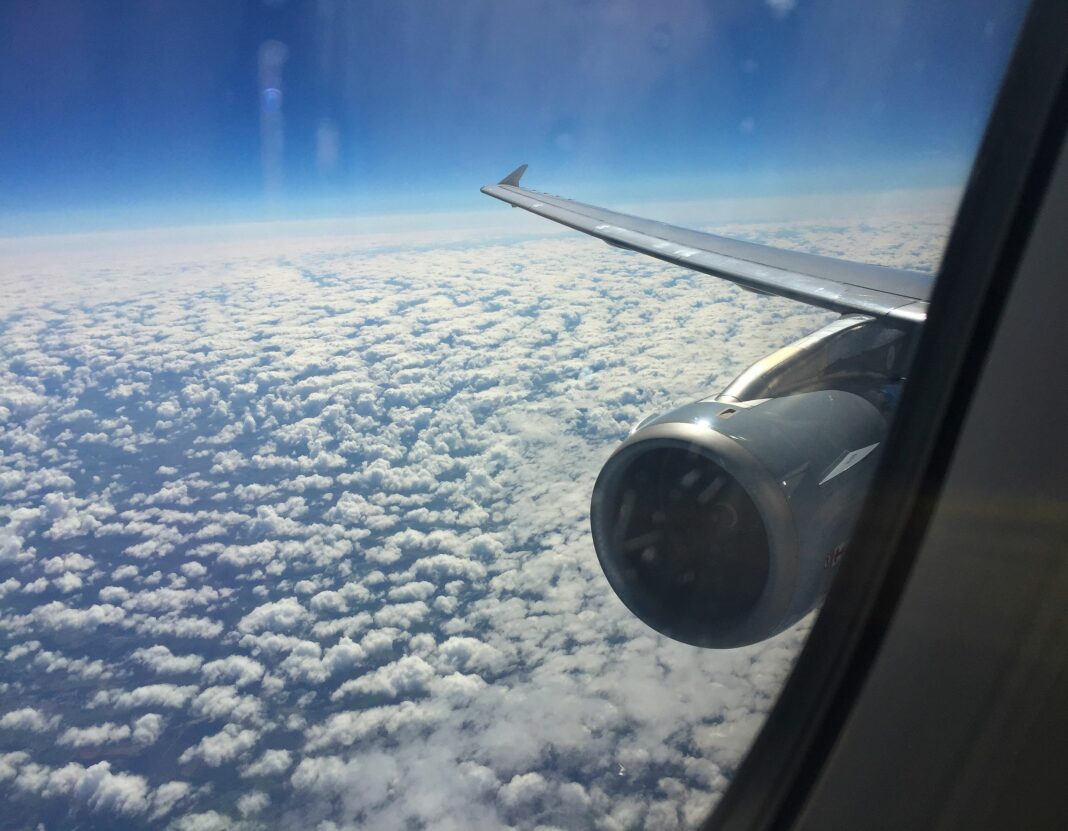 Vue aérienne depuis un avion montrant l'aile et les nuages.