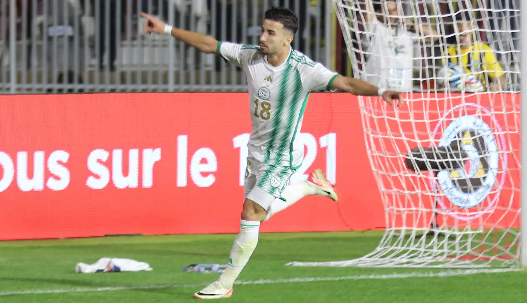 Amoura célèbre un but avec enthousiasme sur le terrain de football.
