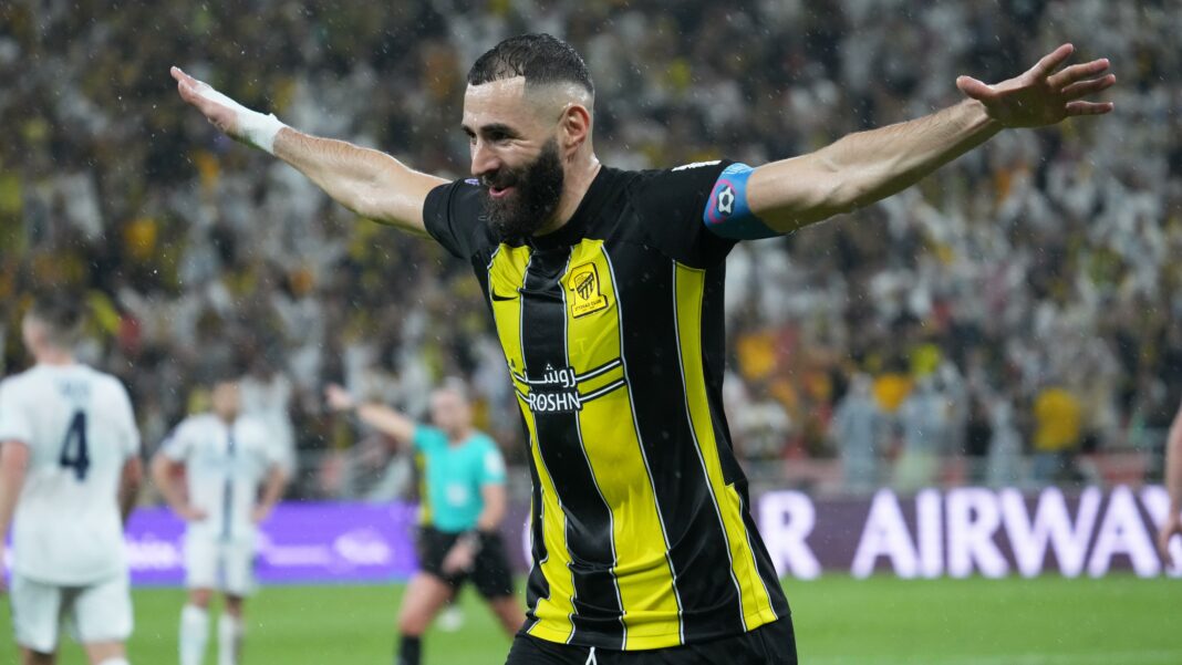 Karim Benzema célèbre avec bras ouverts lors d'un match de football.