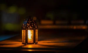 Ramadan 2024 en France : Découvrez les dates de début du jeûne et de l'Aïd el-Fitr Lanterne de Ramadan avec motifs de croissant et d'étoiles, ambiance chaleureuse.