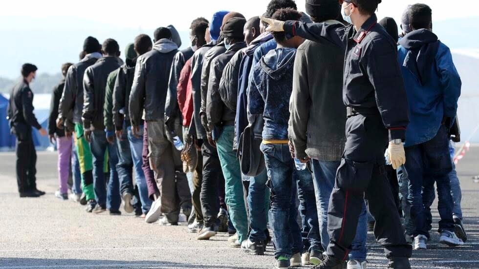 Groupe de migrants en file d'attente pour entrer en France.
