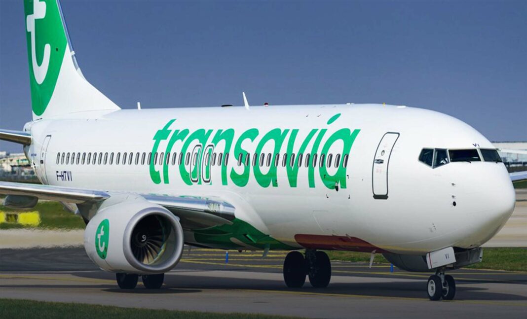 Avion Transavia en atterrissage Avion Transavia blanc avec logo vert en atterrissage sur piste.