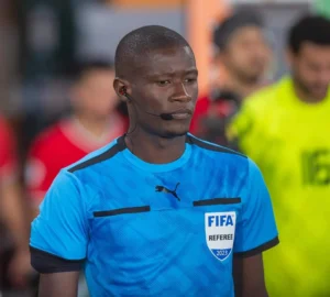 Arbitre FIFA en action lors de la CAN 2023, portant un maillot bleu.