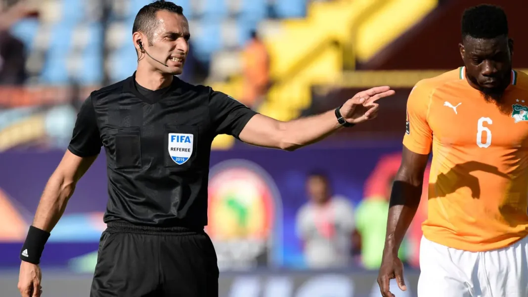 Arbitre FIFA en pleine décision lors d'un match de football.