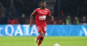 Kylian Mbappé en action sur le terrain, portant le maillot rouge de son équipe.