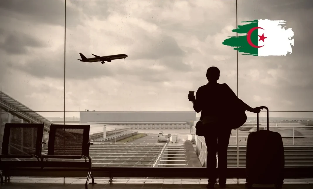 Passager avec valise regardant un avion en vol à l'aéroport.