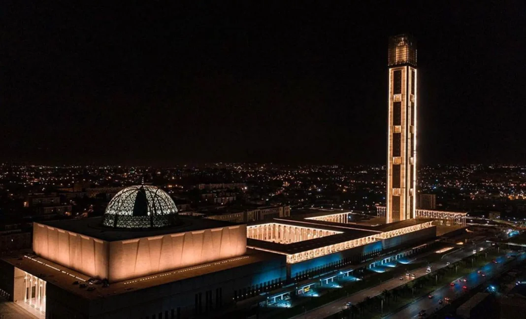 Vue nocturne de la Grande Mosquée d'Alger avec minaret illuminé.