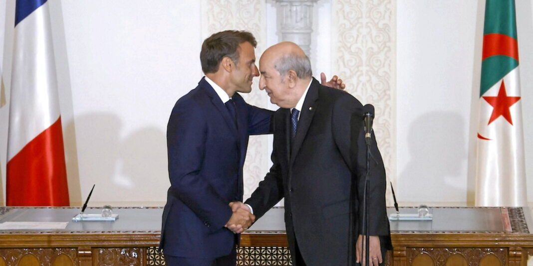 Deux hommes en costume se serrent la main lors d'une rencontre officielle.