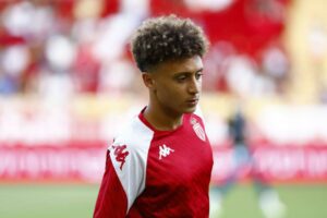 Jeune joueur de football marocain lors d'un match, portant le maillot rouge et blanc.