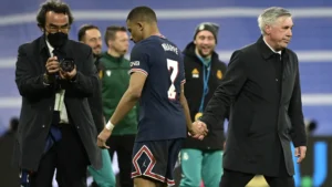 Kylian Mbappe au Réal : du fil à retordre pour Ancelotti Kylian Mbappé serrant la main de l'entraîneur lors d'un match.