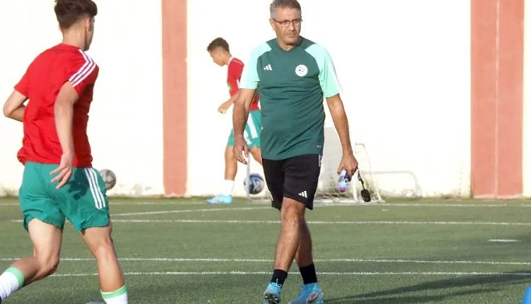 Entraîneur de football donnant des instructions aux jeunes joueurs.