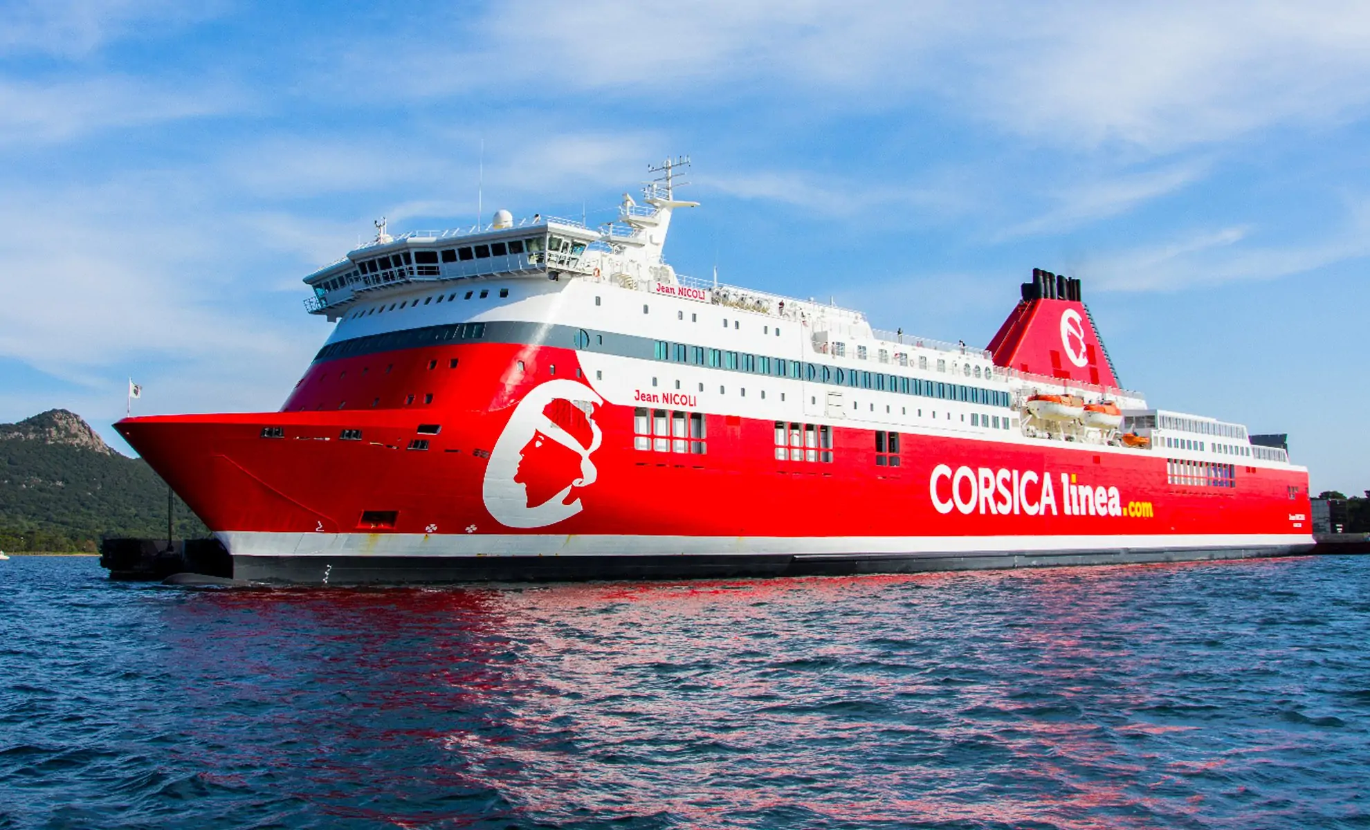 Ferry Corsica Linea rouge en mer avec ciel bleu clair.
