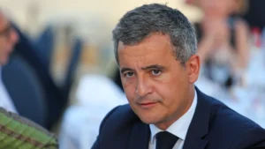 Homme en costume sombre lors d'une réunion officielle.