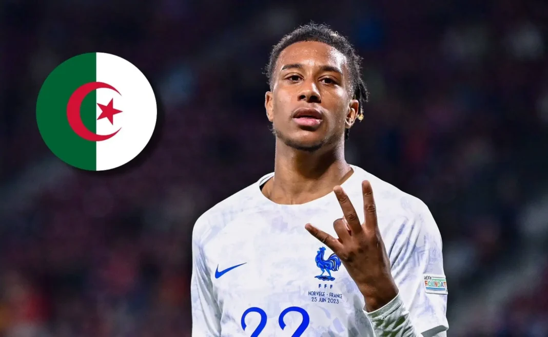 Michael Olise portant le maillot de l'équipe de France, faisant un geste de victoire.
