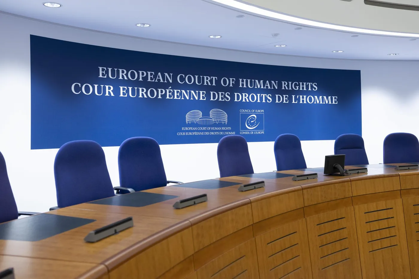 Salle de la Cour Européenne des Droits de l'Homme avec un panneau bleu.