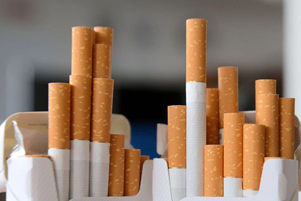 Cigarettes de contrebande empilées dans un carton.