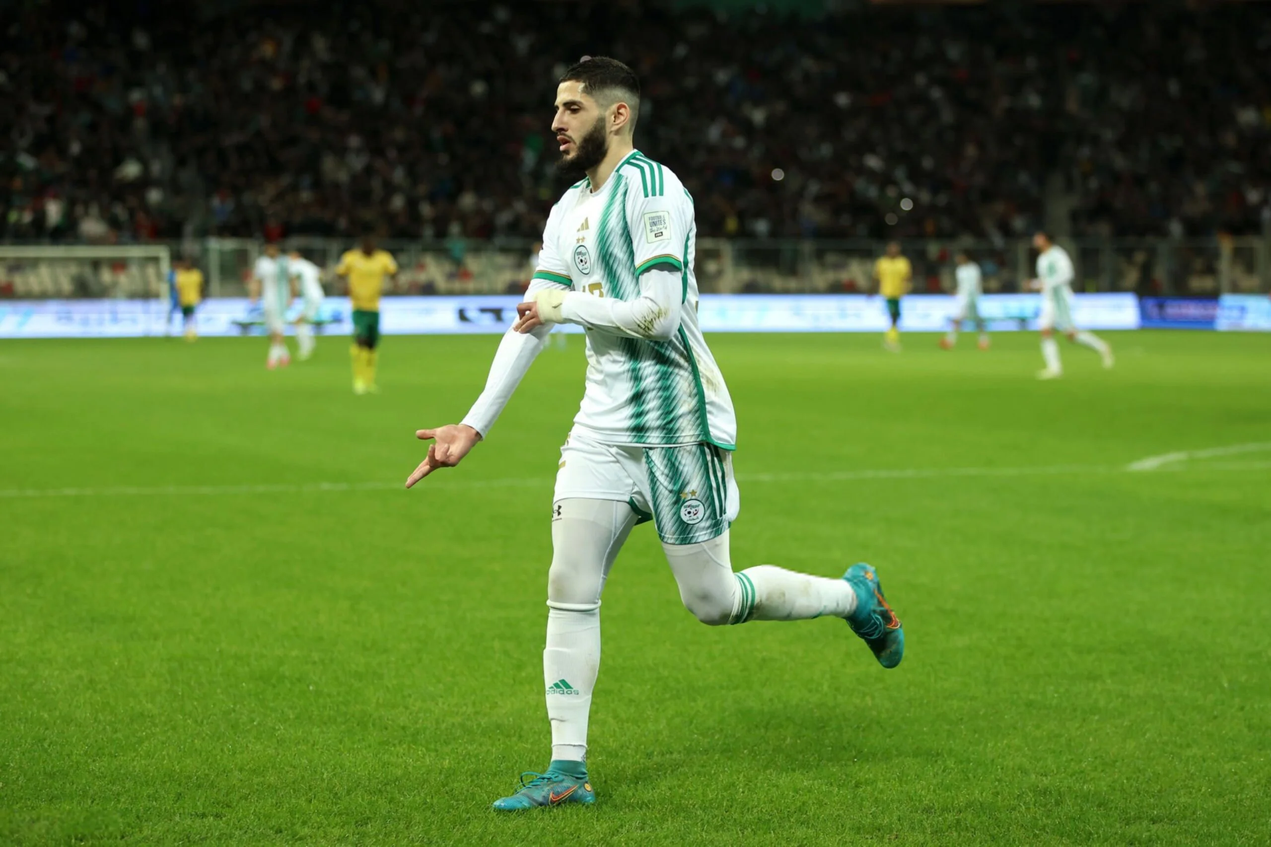 Yassine Benzia en tenue rouge sur le terrain de football.