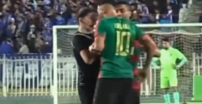 Youcef Belaïli confronté à une arbitre lors d'un match de football.