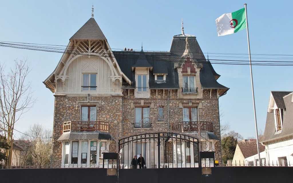 Bâtiment historique du consulat d'Algérie en France avec drapeau algérien.