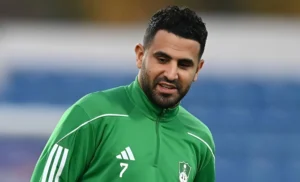 Riyad Mahrez en tenue d'entraînement verte lors d'un match.