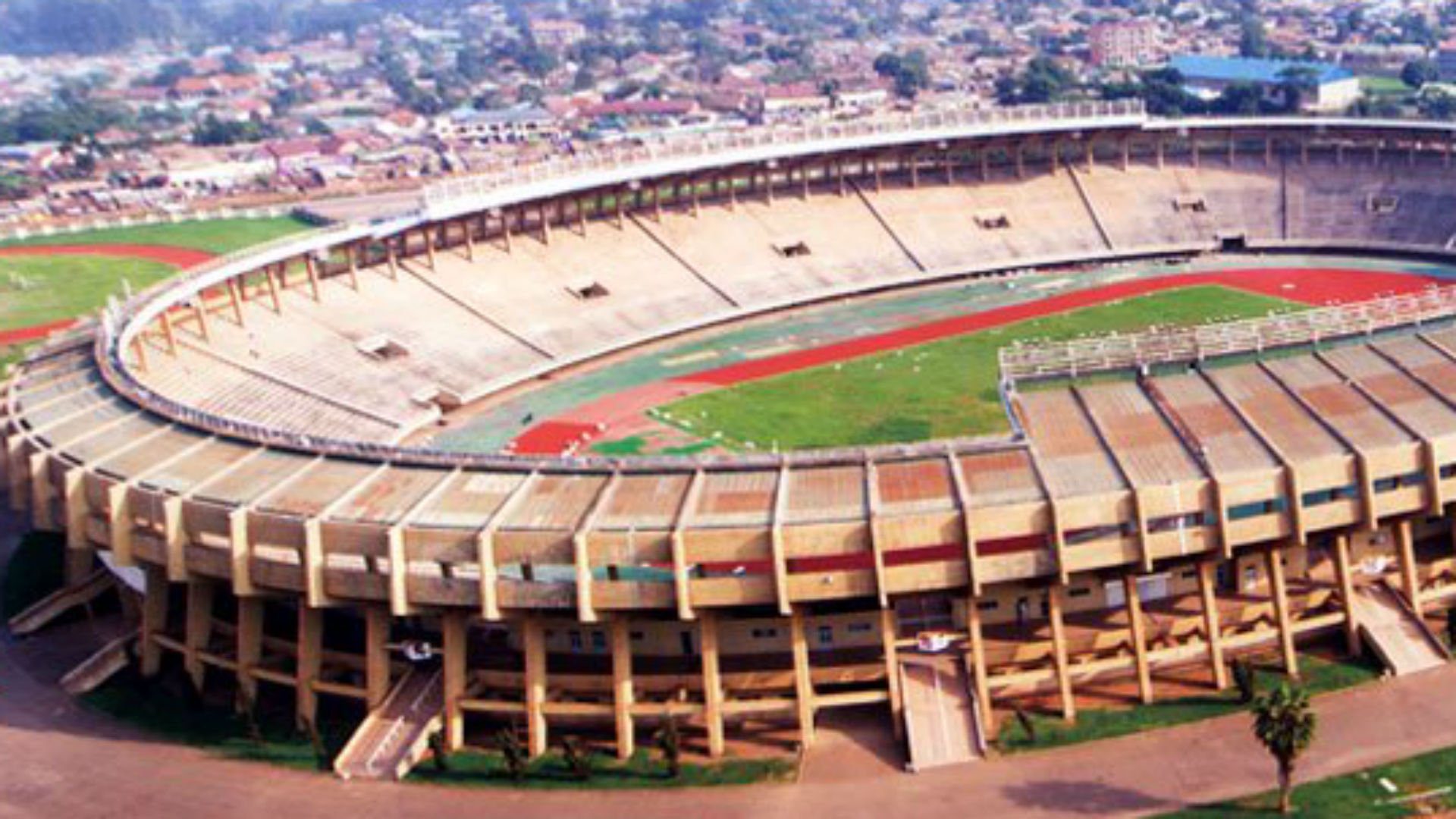 Stade de football vide avec piste d'athlétisme et gradins.