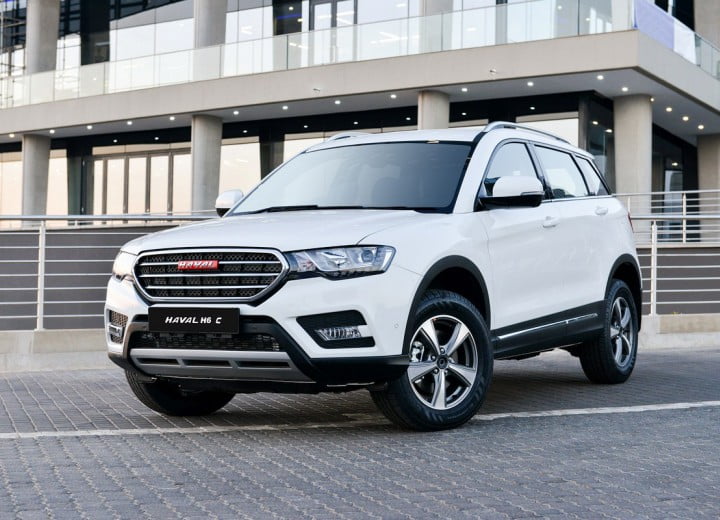 SUV Haval H6 blanc devant un bâtiment moderne en Algérie.