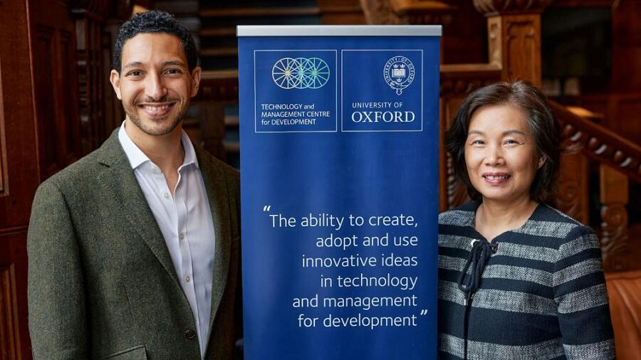 Amir Lebdioui et une collègue devant un panneau de l'Université d'Oxford.