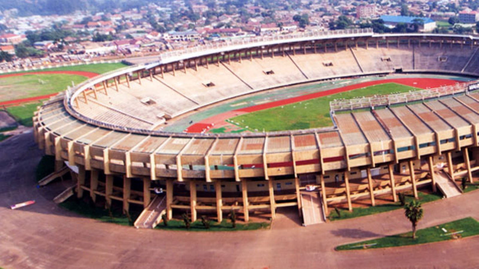 Stade de football vide avec piste d'athlétisme et gradins.
