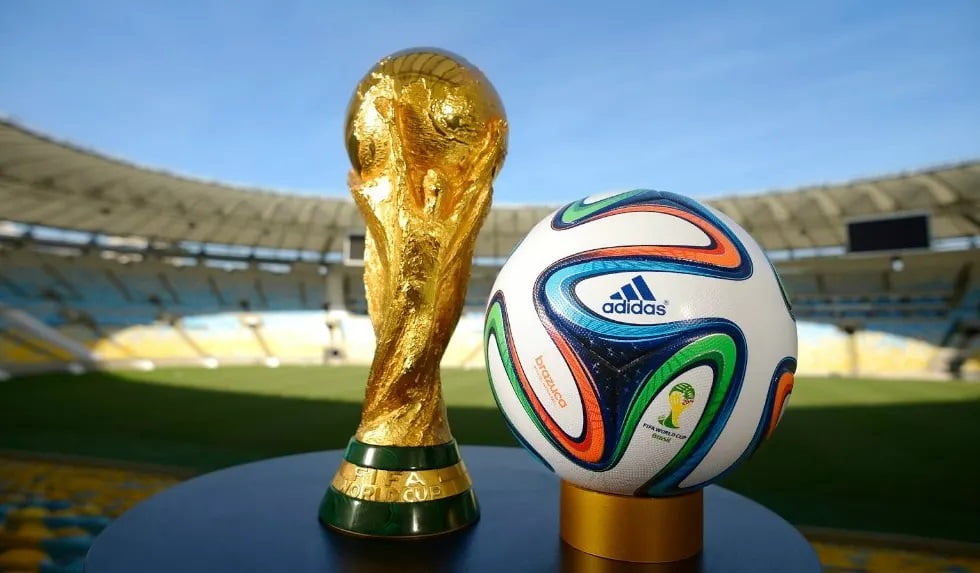 Trophée de la Coupe du Monde 2026 avec ballon officiel sur le stade.