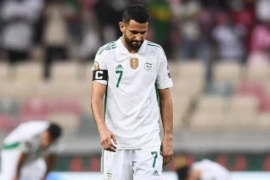 Riyad Mahrez portant le maillot de l'Algérie, déçu après un match.