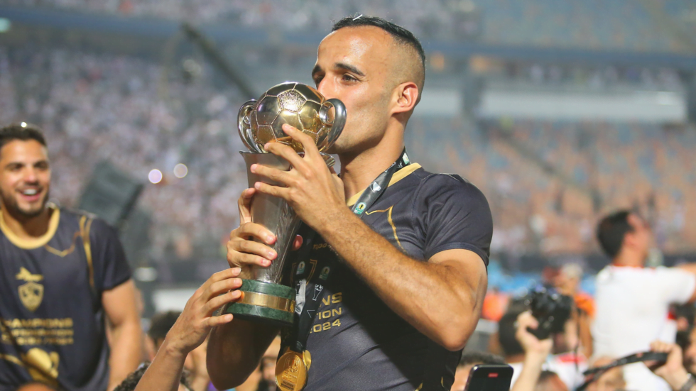 Finale Coupe de la CAF : la Confédération ouvre une enquête contre l'Egypte Joueur de football avec trophée de la Coupe de la CAF.