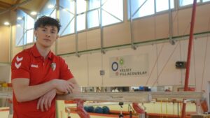 Jeune gymnaste algérien en salle d'entraînement avec équipement sportif.