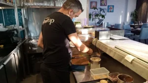 Algérie : A la découverte du chef Rabah Ourrad, l'homme aux multiples potentiels Chef Rabah Ourrad préparant un plat dans un restaurant.