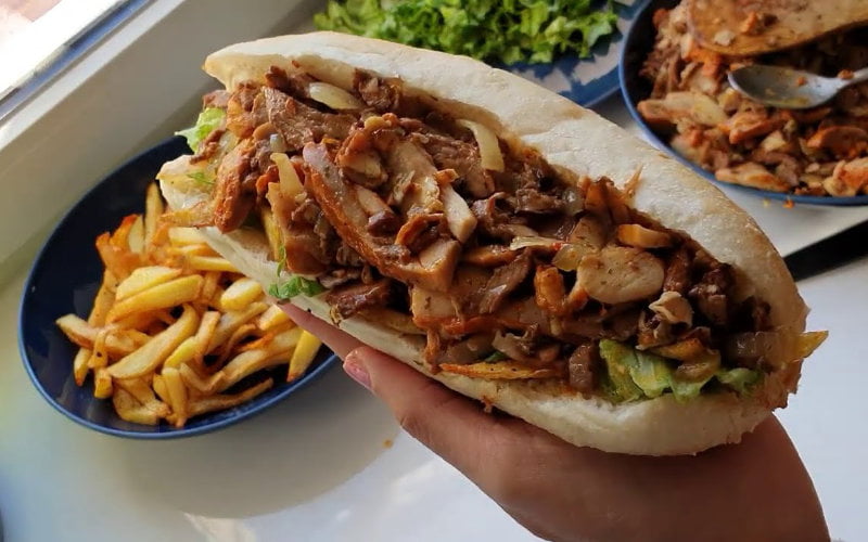Sandwich marocain avec viande, légumes et pain blanc frais.