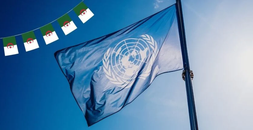 Drapeau de l'ONU flottant avec drapeaux algériens en arrière-plan.