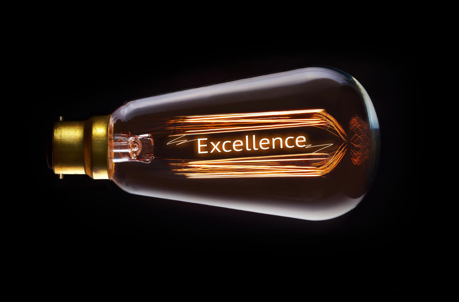 Ampoule avec le mot 'Excellence' illuminé dans l'obscurité.