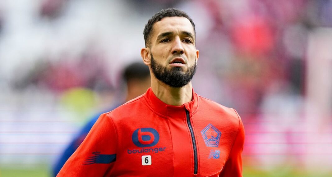 Nabil Bentaleb lors d'un match de football, concentré sur le jeu.