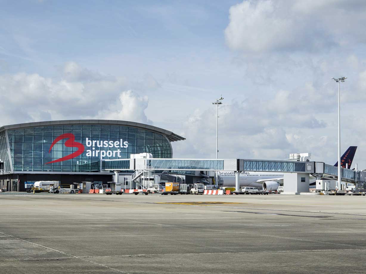Aéroport de Bruxelles avec terminal moderne et avions au sol.
