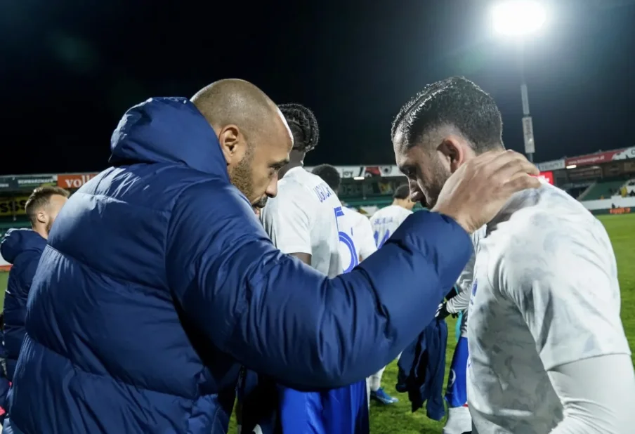 Rayan Cherki avec un entraîneur lors d'un match de football.
