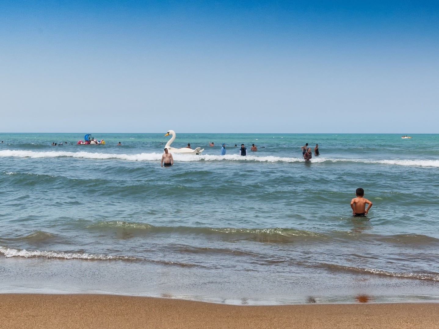 Plage en Algérie avec structures gonflables colorées pour enfants.