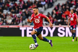 Adam Ounas, une percée inattendue, relance la carrière du Fennec. Direction la Liga? Footballeur en mouvement avec le ballon sur le terrain.