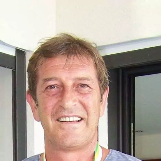 Gilles Morisseau, entraîneur français de MC Alger, souriant devant le stade.