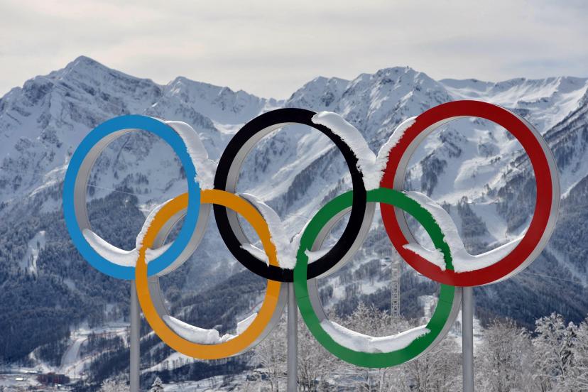 Anneaux olympiques sur fond de montagnes enneigées en France.