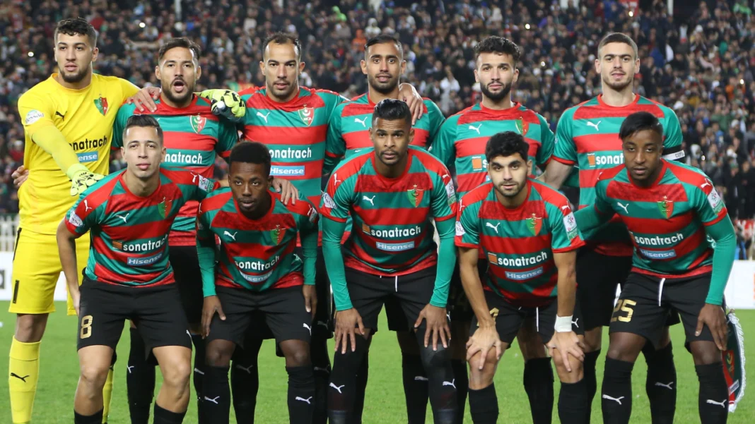 Groupe de joueurs du MC Alger lors d'un match de football.