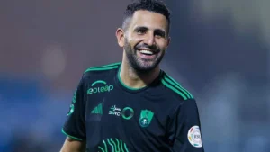 Riyad Mahrez souriant en maillot d'équipe lors d'une rencontre.